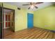 Bedroom featuring wood-look floors, double closet with colored doors and ceiling fan at 112 Camelot Dr, Atlanta, GA 30349