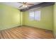 Bright bedroom featuring wood-look floors, ceiling fan and window with natural light at 112 Camelot Dr, Atlanta, GA 30349