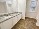 This bathroom offers dual sinks, granite counters, a tub, and stylish flooring at 4337 Ben Hill Rd, Atlanta, GA 30349