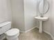 This bathroom offers a clean design with a pedestal sink, round mirror, and tiled floors at 4337 Ben Hill Rd, Atlanta, GA 30349