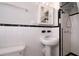 Bright bathroom features white tile with black trim, pedestal sink, medicine cabinet, and walk-in shower at 2785 Toney Dr, Decatur, GA 30032