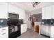 Modern kitchen featuring granite countertops, stainless steel appliances, white cabinets and blue backsplash at 2785 Toney Dr, Decatur, GA 30032