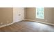 Spacious carpeted bedroom with double doors and a window at 939 Jean Ct, Covington, GA 30014