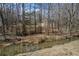 Back of home and creek view through the trees showcasing the property's natural setting at 939 Jean Ct, Covington, GA 30014