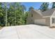 Large two-car garage with concrete driveway and wooded backdrop at 939 Jean Ct, Covington, GA 30014