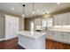 White kitchen island with quartz countertop and modern pendant lighting at 939 Jean Ct, Covington, GA 30014