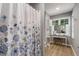 Well-lit bathroom featuring a vanity area, shower with floral curtain, and hardwood flooring at 978 W Mill Bnd, Kennesaw, GA 30152