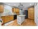 Charming kitchen features wood cabinets, a granite island, stainless steel appliances, and wood floors at 978 W Mill Bnd, Kennesaw, GA 30152