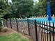 Community pool surrounded by fence, trees and lounge chairs at 978 W Mill Bnd, Kennesaw, GA 30152
