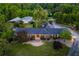 Aerial view of a brick home with a large lawn, mature trees, and a driveway leading to a garage at 3700 Tom Brewer Rd, Loganville, GA 30052