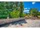 Backyard area with stone retaining walls, and a concrete parking area surrounded by mature trees at 3700 Tom Brewer Rd, Loganville, GA 30052