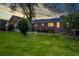 Large backyard with mature trees, grass, and house with lights on at 3700 Tom Brewer Rd, Loganville, GA 30052