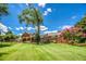 Expansive backyard view with lush green lawn, mature trees, brick home, and covered patio at 3700 Tom Brewer Rd, Loganville, GA 30052