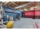 Finished basement features workout equipment, a mirror, blue walls, and colorful red accent wall at 3700 Tom Brewer Rd, Loganville, GA 30052