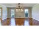 Bright dining room featuring parquet floors, chandelier, and windows with backyard views at 3700 Tom Brewer Rd, Loganville, GA 30052