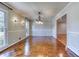 Open dining room featuring parquet floors, chandelier, and bright window views at 3700 Tom Brewer Rd, Loganville, GA 30052