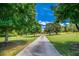 Long driveway leading to a beautiful home, framed by mature trees and lush green lawns at 3700 Tom Brewer Rd, Loganville, GA 30052