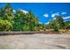 Expansive driveway featuring a lovely stone wall with a lush green backdrop under a beautiful blue sky at 3700 Tom Brewer Rd, Loganville, GA 30052