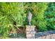 Close-up of the property's lovely lamp post set atop a stone pillar and surrounded by beautiful foliage at 3700 Tom Brewer Rd, Loganville, GA 30052