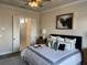 Bedroom with crown moulding, a fan, white bedding, decorative pillows, and view of walk-in closet at 507 Godfrey Dr, Cumming, GA 30040