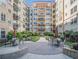 A landscaped courtyard features a fountain and seating areas among apartment buildings with balconies at 230 E Ponce De Leon Ave # 322, Decatur, GA 30030