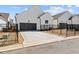 Modern, white home featuring a two-car garage with a black metal gate around the property at 505 Godfrey Dr, Cumming, GA 30040
