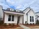 Inviting craftsman-style home with stone columns, dormer windows, and professionally landscaped front yard at 505 Godfrey Dr, Cumming, GA 30040