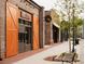 Exterior view of storefronts with wooden doors and outdoor seating areas at 505 Godfrey Dr, Cumming, GA 30040