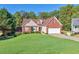 Charming two-story brick home with a well-manicured lawn, complemented by a white garage door at 3076 Harris Mill Ct, Duluth, GA 30096