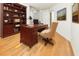 Cozy home office with hardwood floors, built-in shelving, and a comfortable desk and chair at 3076 Harris Mill Ct, Duluth, GA 30096