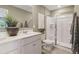 Modern bathroom featuring double sinks, white cabinets, an enclosed glass shower, and a large mirror at 5895 Mattan Trl, Lithonia, GA 30058