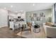 Bright living room with open floor plan featuring a kitchen with white cabinets and stainless steel appliances at 5895 Mattan Trl, Lithonia, GA 30058