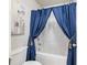 Clean bathroom with a shower/tub combo and blue curtains at 90 Piedmont Cir, Covington, GA 30016