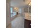 Bathroom with tiled floors, soaking tub, vanity with sink, bright windows, and glass shower at 90 Piedmont Cir, Covington, GA 30016