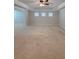 Open bedroom design, featuring a neutral carpet, tray ceiling, and three bright windows at 90 Piedmont Cir, Covington, GA 30016