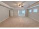 Spacious bedroom has neutral carpets, tray ceiling, and three bright windows for natural light at 90 Piedmont Cir, Covington, GA 30016