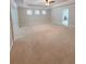 Open bedroom design, featuring a neutral carpet, tray ceiling, and three bright windows at 90 Piedmont Cir, Covington, GA 30016