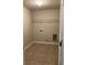 Simple laundry room with overhead shelving and tile floor at 90 Piedmont Cir, Covington, GA 30016