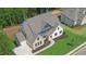 Luxury home with gray roof, large driveway and landscaped lawn at 5693 Brendlynn Dr, Suwanee, GA 30024