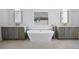 Spa-like bathroom with freestanding tub and dual vanities at 5693 Brendlynn Dr, Suwanee, GA 30024