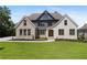 Two-story home with brick and stone accents, and a lush green lawn at 5693 Brendlynn Dr, Suwanee, GA 30024