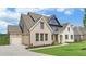 Two-story home with brick exterior, three-car garage, and nicely landscaped lawn at 5693 Brendlynn Dr, Suwanee, GA 30024