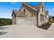 Three-car garage with white doors and a large concrete driveway at 5693 Brendlynn Dr, Suwanee, GA 30024