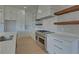 Modern kitchen with white cabinets, marble countertops and a statement range hood at 5693 Brendlynn Dr, Suwanee, GA 30024