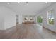 Open concept kitchen with island, white cabinets and hardwood floors at 5693 Brendlynn Dr, Suwanee, GA 30024