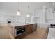 Modern kitchen with a large island, built-in microwave, and stainless steel appliances at 5693 Brendlynn Dr, Suwanee, GA 30024