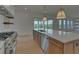 Open concept kitchen with stainless steel appliances and island overlooking the backyard at 5693 Brendlynn Dr, Suwanee, GA 30024