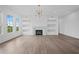 Bright living room with hardwood floors, fireplace, and built-in shelving at 5693 Brendlynn Dr, Suwanee, GA 30024