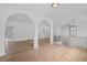 Bright loft area with hardwood floors, black railing, and a modern light fixture at 5693 Brendlynn Dr, Suwanee, GA 30024