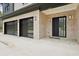 View of two-car garage and front door, made of black with metal accents at 2861 Tree Top Rd, Dacula, GA 30019